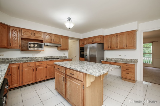 2755 Newport Dr, Naperville, IL 60565 - kitchen with black appliances, under cabinet range hood, a kitchen island, light stone counters, and light tile patterned floors