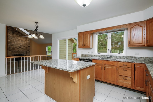 2755 Newport Dr, Naperville, IL 60565 - kitchen with light tile patterned floors, light stone counters, a center island, a kitchen bar, and brown cabinetry
