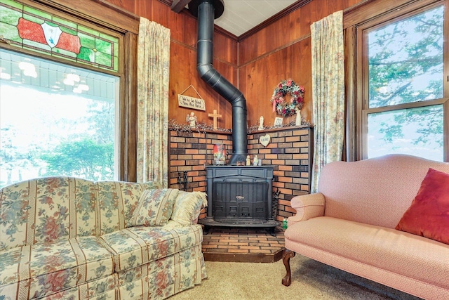 2385 County Road 1550, Saint Joseph, IL 61873 - living area featuring a wood stove, carpet, plenty of natural light, ornamental molding, and wooden walls