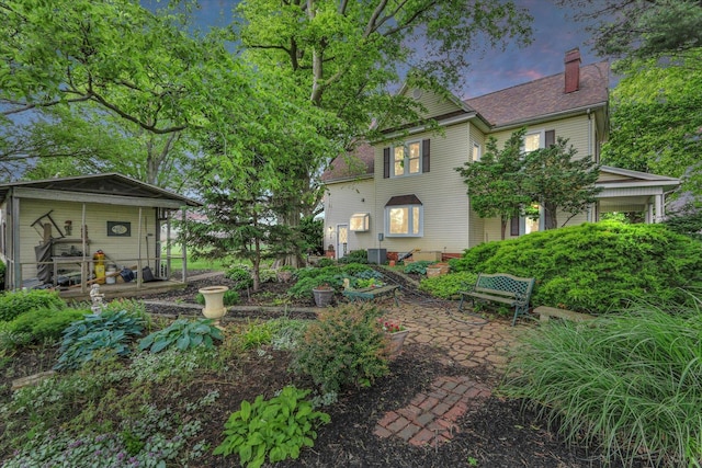 2385 County Road 1550, Saint Joseph, IL 61873 - view of front facade featuring a chimney, cooling unit, and a patio area