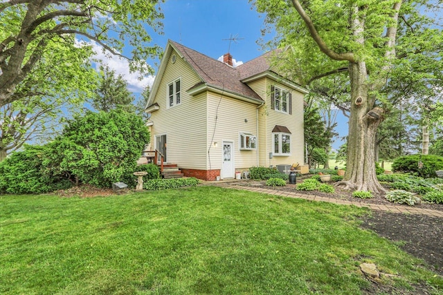 2385 County Road 1550, Saint Joseph, IL 61873 - back of property featuring a yard, roof with shingles, and a chimney