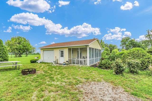 2385 County Road 1550, Saint Joseph, IL 61873 - back of house with a sunroom, a fire pit, a yard, and a garage