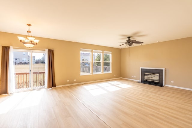 2197 Wilson Creek Cir, Aurora, IL 60503 - unfurnished living room with light wood-style floors, baseboards, a ceiling fan, and a tile fireplace