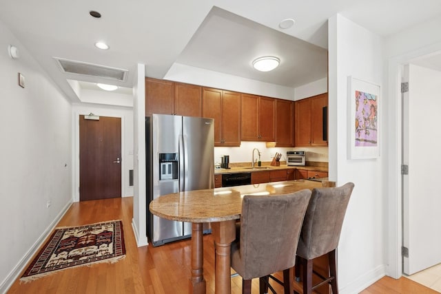 130 N Garland Ct Unit 2406, Chicago, IL 60602 - kitchen with stainless steel fridge, a sink, light wood finished floors, and a kitchen breakfast bar