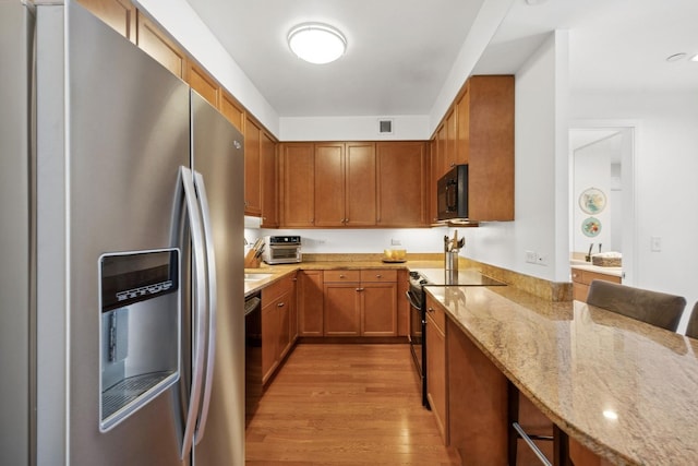 130 N Garland Ct Unit 2406, Chicago, IL 60602 - kitchen with stainless steel refrigerator with ice dispenser, black microwave, range with electric cooktop, light wood-type flooring, and light stone counters