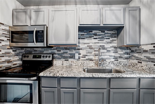 2640 Westbrook Dr, Franklin Park, IL 60131 - kitchen featuring stainless steel appliances, gray cabinets, decorative backsplash, and light stone counters