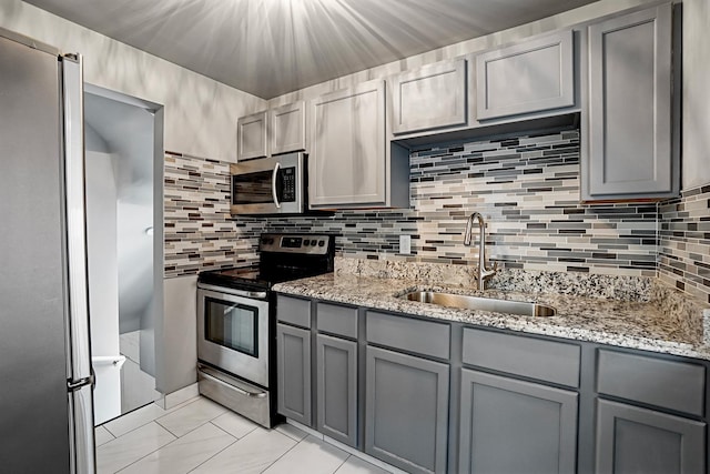 2640 Westbrook Dr, Franklin Park, IL 60131 - kitchen featuring stainless steel appliances, gray cabinets, light stone counters, and decorative backsplash