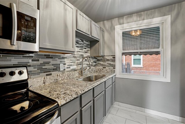 2640 Westbrook Dr, Franklin Park, IL 60131 - kitchen with stainless steel appliances, gray cabinetry, backsplash, and light stone counters