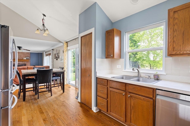 25516 W Gateway Cir, Plainfield, IL 60585 - kitchen with a sink, stainless steel appliances, vaulted ceiling, brown cabinets, and light wood-style floors