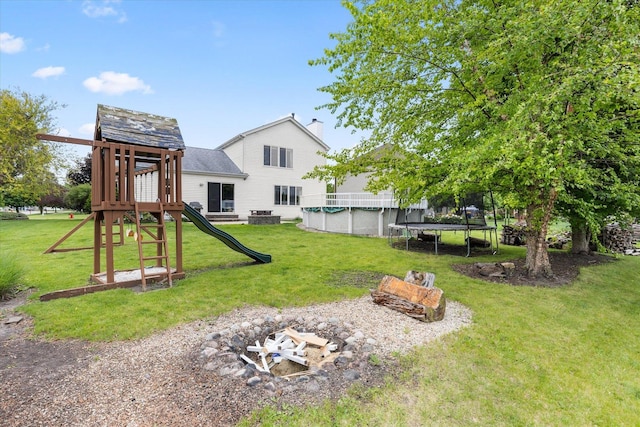 25516 W Gateway Cir, Plainfield, IL 60585 - view of green lawn with a playground, a covered pool, a trampoline, and an outdoor fire pit