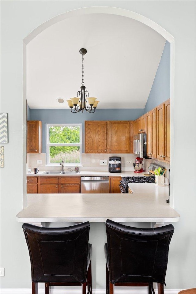 25516 W Gateway Cir, Plainfield, IL 60585 - kitchen featuring stainless steel appliances, a sink, light countertops, a chandelier, and a peninsula