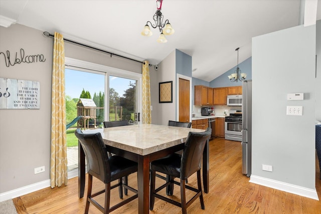 25516 W Gateway Cir, Plainfield, IL 60585 - dining space featuring a chandelier, baseboards, light wood-style floors, and lofted ceiling