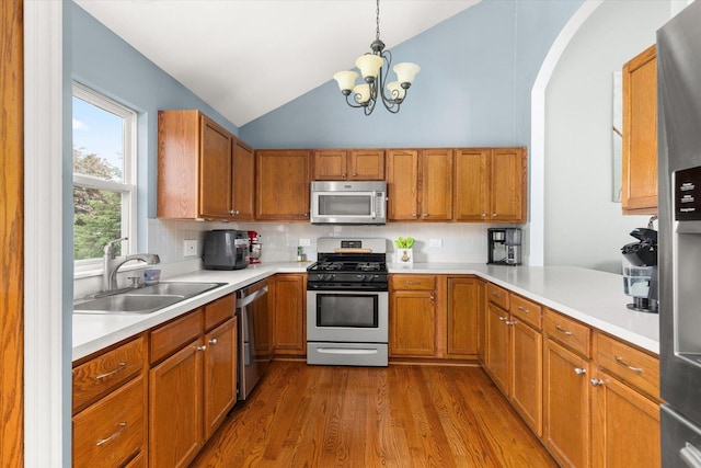25516 W Gateway Cir, Plainfield, IL 60585 - kitchen with stainless steel appliances, a sink, lofted ceiling, light countertops, and brown cabinetry