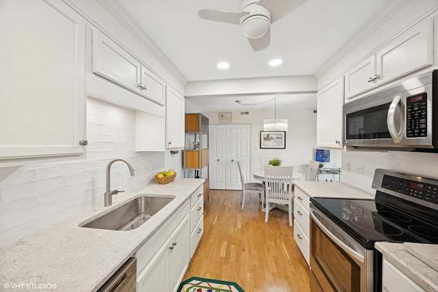 17 N Madison Ave Unit 4, La Grange, IL 60525 - kitchen featuring appliances with stainless steel finishes, a sink, white cabinets, light wood-type flooring, and tasteful backsplash