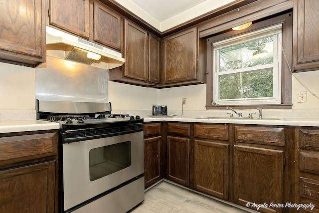 1720 Rogers Ave, Mchenry, IL 60050 - kitchen with stainless steel gas range oven, under cabinet range hood, a sink, and light countertops