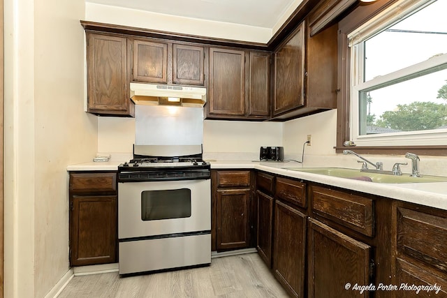 1720 Rogers Ave, Mchenry, IL 60050 - kitchen featuring gas stove, a sink, under cabinet range hood, and light wood-style flooring