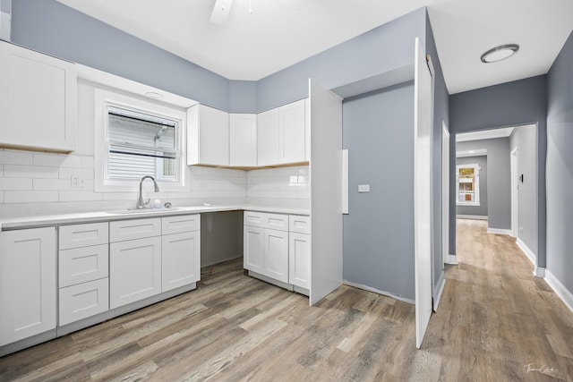 8425 S Essex Ave, Chicago, IL 60617 - kitchen featuring a sink, tasteful backsplash, white cabinets, and light wood-style floors