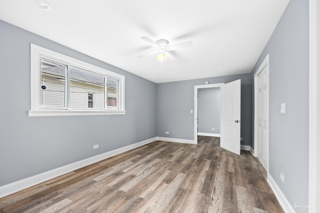 8425 S Essex Ave, Chicago, IL 60617 - unfurnished bedroom with a closet, wood finished floors, baseboards, and a ceiling fan