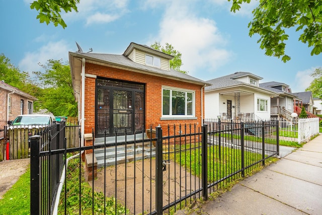 8425 S Essex Ave, Chicago, IL 60617 - bungalow with brick siding, a gate, a fenced front yard, and roof with shingles