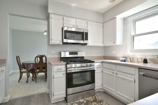 1557 Scottdale Cir, Wheaton, IL 60189 - kitchen with appliances with stainless steel finishes, a sink, light countertops, and white cabinets
