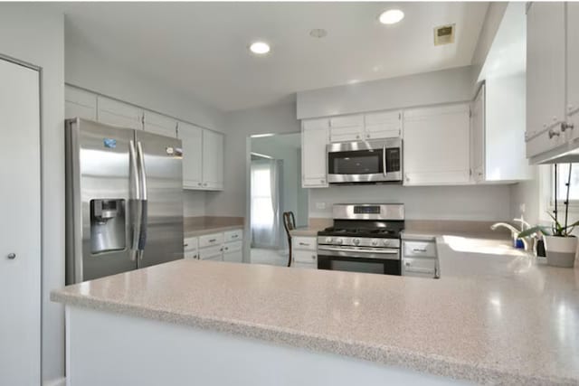 1557 Scottdale Cir, Wheaton, IL 60189 - kitchen with appliances with stainless steel finishes, a sink, a peninsula, white cabinetry, and recessed lighting