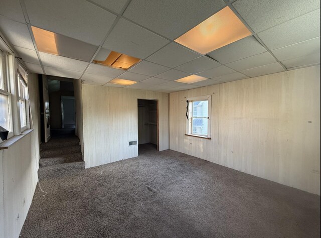 705 Campbell St, Joliet, IL 60435 - carpeted empty room with a paneled ceiling and wooden walls