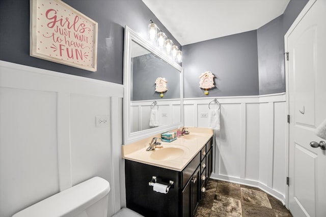 1651 Glenbrooke Ln, New Lenox, IL 60451 - full bathroom featuring a decorative wall, stone finish floors, double vanity, wainscoting, and toilet