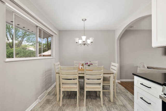 300 N 3rd St, Elburn, IL 60119 - dining room with arched walkways, a chandelier, baseboards, and light wood-style floors