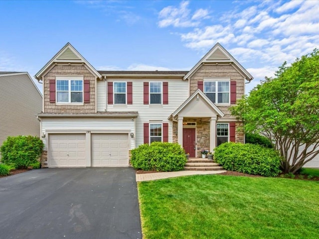 195 E Clover Ave, Cortland, IL 60112 - view of front of property with asphalt driveway, a garage, stone siding, and a front lawn