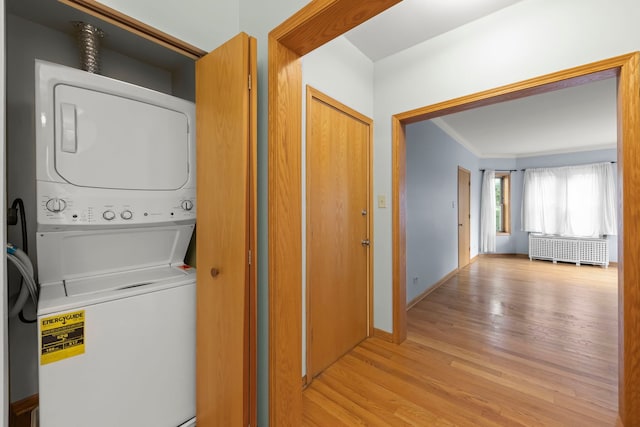 405 S Harvey Ave Unit 2A, Oak Park, IL 60302 - laundry room featuring stacked washer and clothes dryer, radiator, light wood finished floors, crown molding, and baseboards