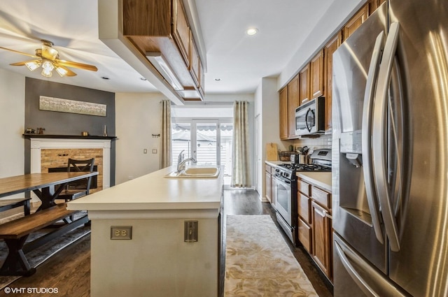 5932 N Sauganash Ln, Chicago, IL 60646 - kitchen featuring stainless steel appliances, a sink, brown cabinets, dark wood finished floors, and recessed lighting