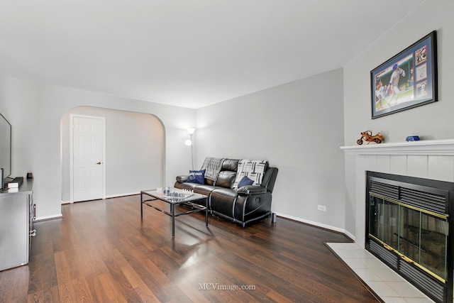 7811 W 157th St Unit 2N, Orland Park, IL 60462 - living area with arched walkways, wood finished floors, a tile fireplace, and baseboards