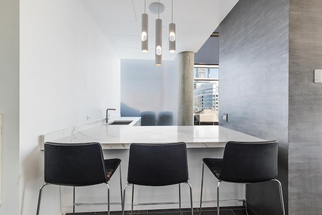 600 N Fairbanks Ct Unit 2503, Chicago, IL 60611 - kitchen featuring a sink, a peninsula, pendant lighting, and light stone counters