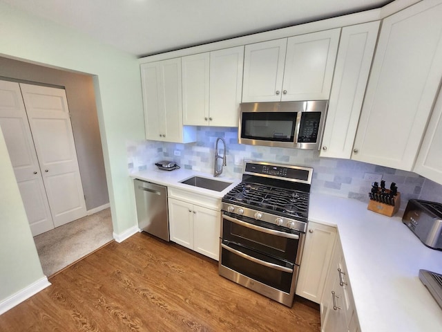 271 E Cleburne Ave, Bartlett, IL 60103 - kitchen featuring appliances with stainless steel finishes, a sink, light countertops, and white cabinetry