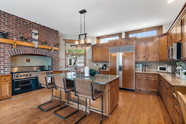 10731 Somonauk Rd, Hinckley, IL 60520 - kitchen with premium appliances, backsplash, a center island, light stone countertops, and recessed lighting