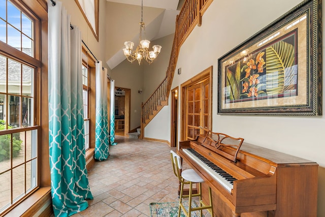 10731 Somonauk Rd, Hinckley, IL 60520 - entryway with high vaulted ceiling, a chandelier, baseboards, stone finish flooring, and stairway