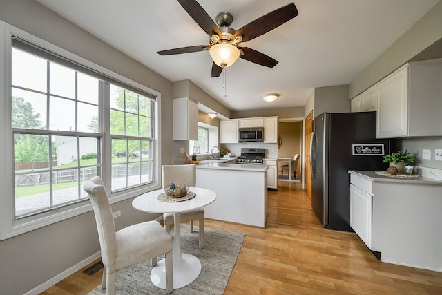 1068 Big Eagle Trl, Carol Stream, IL 60188 - kitchen with stainless steel appliances, a sink, a ceiling fan, white cabinets, and light wood finished floors