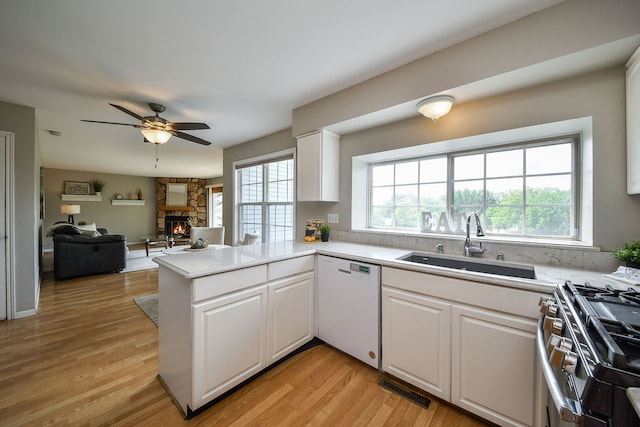 1068 Big Eagle Trl, Carol Stream, IL 60188 - kitchen with white dishwasher, stainless steel gas range, a sink, a ceiling fan, and a peninsula
