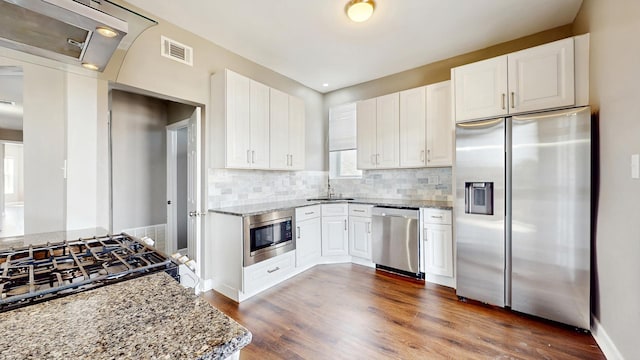 6347 S Drexel Ave, Chicago, IL 60637 - kitchen with appliances with stainless steel finishes, a sink, light stone countertops, decorative backsplash, and dark wood-style floors