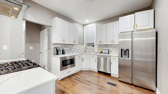 6347 S Drexel Ave, Chicago, IL 60637 - kitchen featuring stainless steel appliances, white cabinetry, decorative backsplash, a sink, and recessed lighting