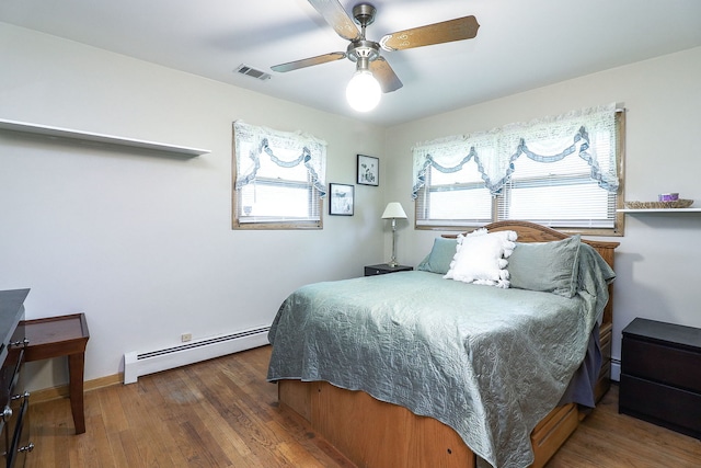 1320 Adeline Ct, Aurora, IL 60505 - bedroom featuring a baseboard heating unit, multiple windows, and wood finished floors