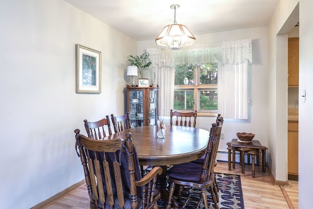 1320 Adeline Ct, Aurora, IL 60505 - dining area featuring a chandelier, light wood-type flooring, a baseboard radiator, and baseboards