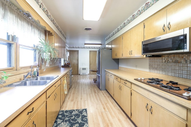 1320 Adeline Ct, Aurora, IL 60505 - kitchen featuring appliances with stainless steel finishes, a sink, light countertops, tasteful backsplash, and light wood-style floors