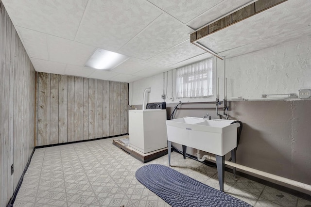 5548 S Kedvale Ave, Chicago, IL 60629 - below grade area featuring washing machine and dryer, wooden walls, light floors, a sink, and baseboards
