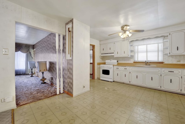 5548 S Kedvale Ave, Chicago, IL 60629 - kitchen featuring white range oven, ceiling fan, a sink, white cabinetry, and wallpapered walls