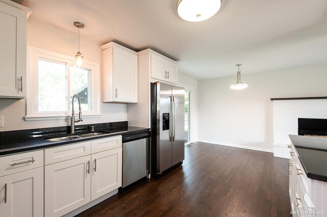 5700 Grange Ave, Oak Forest, IL 60452 - kitchen featuring appliances with stainless steel finishes, a sink, dark countertops, dark wood-style floors, and decorative light fixtures
