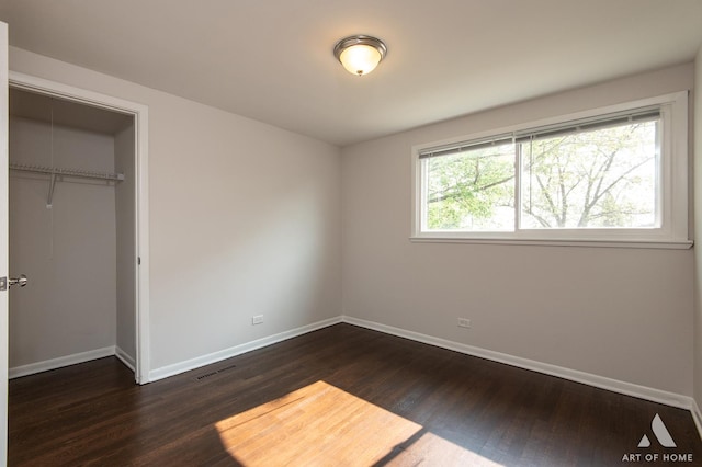 5700 Grange Ave, Oak Forest, IL 60452 - unfurnished bedroom with dark wood finished floors, baseboards, and a closet