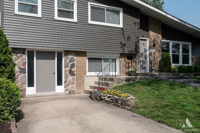 5700 Grange Ave, Oak Forest, IL 60452 - view of exterior entry with a lawn, brick siding, and a patio area