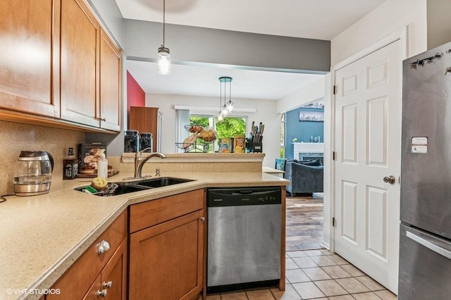 1063 Ridgefield Cir, Carol Stream, IL 60188 - kitchen with appliances with stainless steel finishes, a peninsula, light countertops, pendant lighting, and light tile patterned flooring