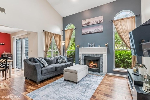 1063 Ridgefield Cir, Carol Stream, IL 60188 - living room featuring wood finished floors, a towering ceiling, a high end fireplace, and healthy amount of natural light